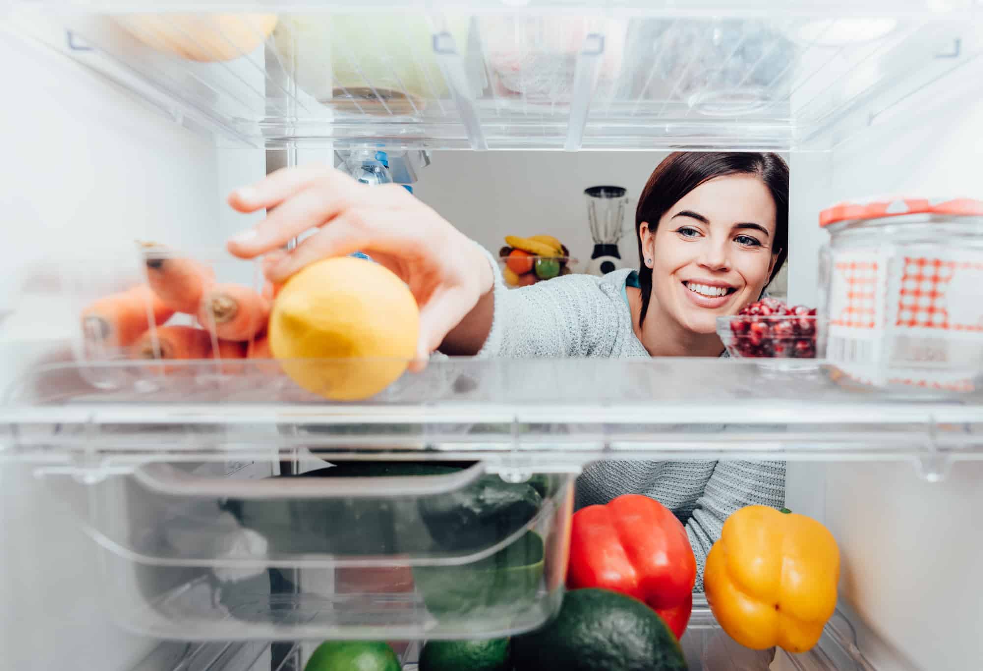 CW Services Inc: Woman taking a lemon out of the fridge